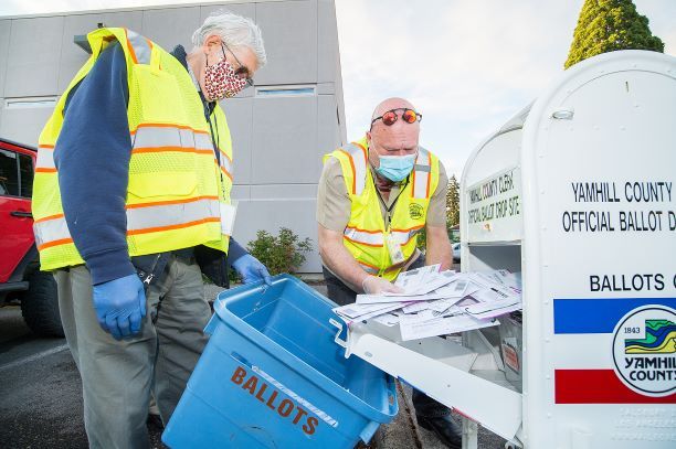 Marcus Larson/News-Register##Ballot collection volunteers Darrell King and Eric Wright collect ballots just after 8 p.m. on election night from the Yamhill County Courthouse box.