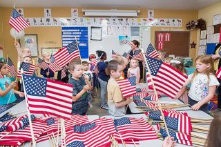 Marcus Larson/News-Register##
McMinnville Christian Academy teacher Tara Hessell, center, talks to her students about the importance of Memorial Day  and how to show respect
for the flag. Students in all grades are setting out 5,924 flags today,
representing every Oregonian killed in service to their country. Flags
will be on display through Memorial Day in front of the school at 325
N.W. Baker Creek Road. Veterans will hold a public ceremony at the site at 1:30 Monday afternoon.