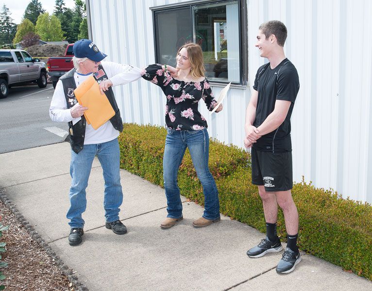 Marcus Larson/News-Register##During an American Legion Post 21 Riders Scholarship ceremony last week, Libby Glassley of Dayton High School elbow bumps Mike Paull after receiving her award. Jakob Jarvis, right, of Yamhill-Carlton, Madeline Smith of McMinnville and Paul Morris of Willamina also received the $1,000 scholarships.