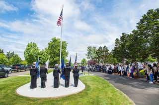 Marcus Larson/News-Register##
A large crowd gathers, hands over hearts, for a ceremonial rifle salute
followed by the playing of  Taps  in remembrance of those who served
during a Memorial Day ceremony at Evergreen cemetery.