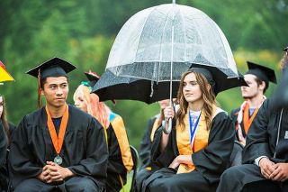 Marcus Larson/News-Register##
Salutatorian Taryn Hunt shields herself from the rain during Willamina High School’s graduation ceremony Saturday afternoon.