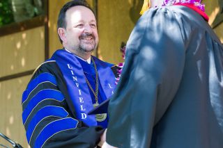 Marcus Larson/News-Register
##Linfield President Thomas Hellie shakes the hand of a graduate during his last commencement ceremony as head of the college. Hellie will retire in June after 12 years in the position.