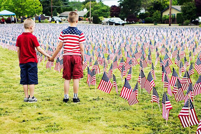 Rockne Roll/News-Register##
From left, McMinnville Christian Academy students and brothers Sutton Buller, 6, and Jackson Buller, 9, observe their school s Memorial Day flag display Friday, May 25. Their father, an army infantryman, was deployed to Iraq from 2003-2005.