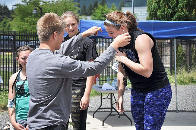 Robert Husseman/News-Register##Amity senior Lindsay McShane (right) receives a second-place medal from the 2016 Oregon State High School Hammer Championships, held Sunday at Newberg’s Austin Sports Complex, from Newberg senior and boys’ state champion Hap Frketich.