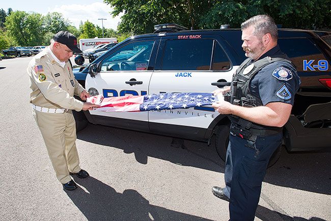 Marcus Larson/News-Register
Veteran Angel Mendoza and McMinnville Police officer Mike LaRue properly fold an American flag to be used for the new police program that aims to give deceased veterans the honor they deserve.
