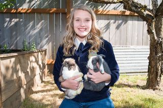 Marcus Larson/News-Register ##
Grace Adams poses in the backyard of her mother’s McMinnville home with her mom’s rabbits, Paddington and Panda. As president of the state organization, the graduating senior is looking forward to leading a team of FFA officers. Serving at the state level has been a goal since she was a freshman.