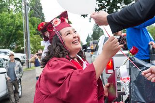 Rusty Rae/News-Register##Dayton High School graduate Yessica Rojas-Carrillo accepts a rose and a balloon, along with her diploma, from Principal Mike Solem during a parade following the commencement ceremony. Rusty Rae/News-Register##Dayton High School graduate Yessica Rojas-Carrillo accepts a rose and a balloon, along with her diploma, from Principal Mike Solem during a parade following the commencement ceremony.