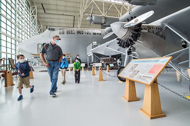 Marcus Larson/News-Register##On the first day of Evergreen Aviation Museum’s reopening, James Geyer and his four grandchildren, from left, Ryan Cover, Boman Geyer, Nicky Geyer, and Grace Geyer tour the wide variety of planes on display.