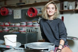 Rockne Roll/News-Register##Mya Clover-Owens sits at the pottery wheel in the McMinnville High School art room. She fell in love with ceramics and other forms of art at Mac High and won a national competition with one of her vases.