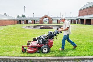 Marcus Larson/News-Register##Linfield facilities worker John Holland mows the grass near the athletic facilities on campus. The campus reopened in mid-June and will look its best when the name changes to Linfield University July 1. Marcus Larson/News-Register##Linfield facilities worker John Holland mows the grass near the athletic facilities on campus. The campus reopened in mid-June and will look its best when the name changes to Linfield University July 1.