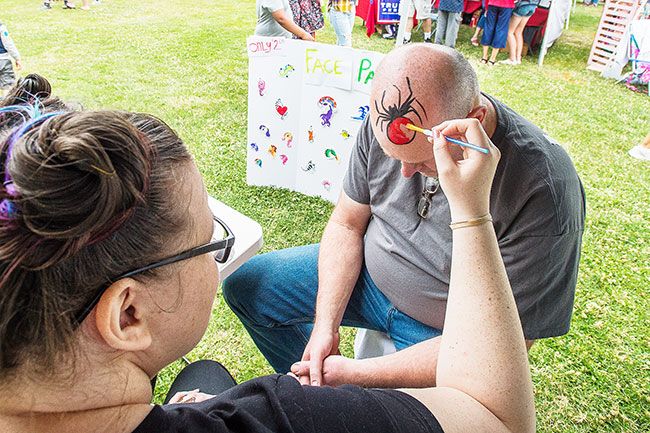 Marcus Larson/News-Register##
Artist Shawna Lanyon paints a spider on the head of  Fritz Waechtler to
commemorate a similar face painting he received years ago at Carlton Fun
Days.