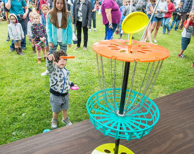 Marcus Larson/News-Register##
Gabriel Genco, 3, throws a miniature Frisbee into a disc golf basket as
part of the Carlton Fun Days kids  games.