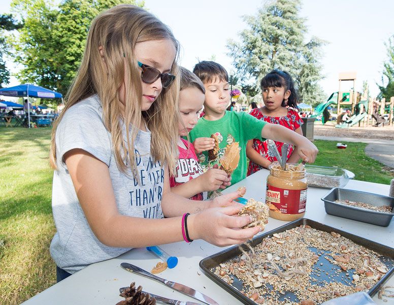 Marcus Larson/News-Register##
Lucy Wright and other children make pine cone peanut butter bird feeders during the Dayton Friday Nights event.