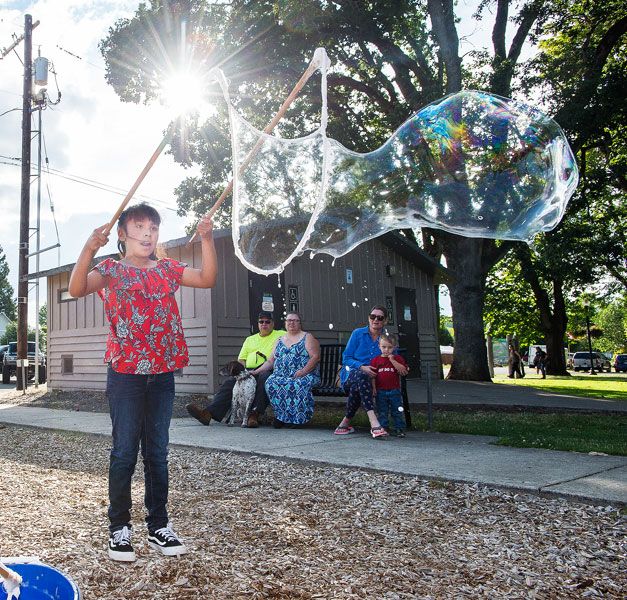 Marcus Larson/News-Register##
Eight-year-old Monce Martinez uses a pair of sticks and some string to make giant soap bubbles, a fun childrens activity at Dayton Friday Nights.