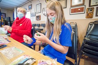 Marcus Larson/News-Register##Lilly Riha sews a mask ear saver under the guidance of her grandmother, Jeanne Clayton