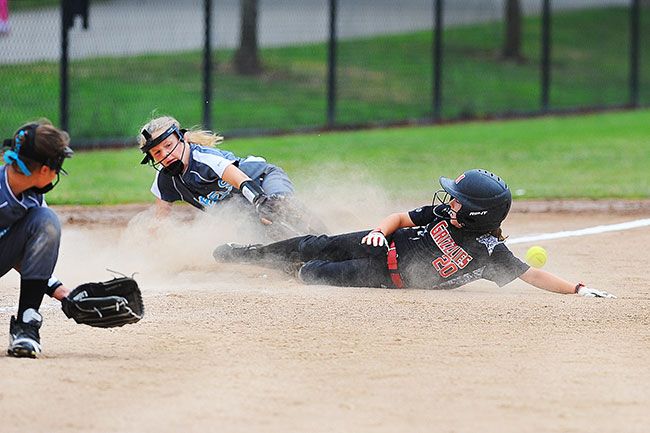 Rusty Rae/News-Register##
Hallie Woods slides into third base, as the Canby throw goes awry during play at the USA state championship.