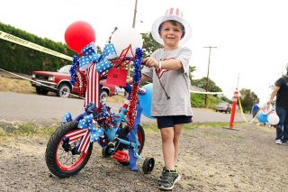 Anna Lieberman/News-Register##Camden Vorderstrasse stands by his tricycle, won of the winners at Lafayette s bike parade. When his grandparents asked about his favorite part of the Fourth of July, he said  the decorations. 