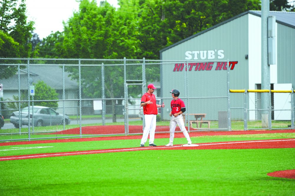 Logan Brandon/News-Register##
Hyder Dental head coach Todd Peterson explains a baserunning technique to centerfielder Cody Miller during Tuesday’s 9-7 victory over Tualatin Premier.