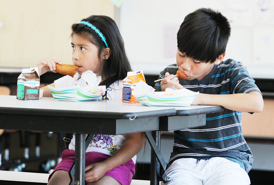 Rockne Roll/News-Register##
From left, Camila, 7, and Ronaldo Grimaldo, 10, dig into lunch at McMinnville School District summer lunch program Wednesday, July 12, at Sue Buel Elementary School in McMinnville.