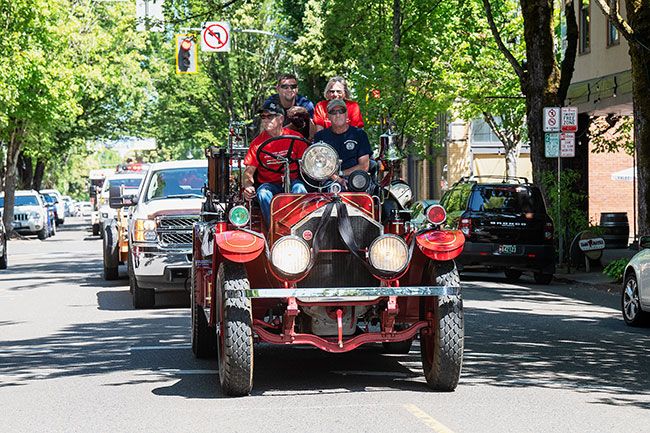 Rusty Rae/News-Register##
Former longtime fire chief Jerry Smith’s son Jeff, grandson Justin and daughter, Marsha, ride atop vintage Engine No. 1 driven by Dwight Sturm during a fire equipment parade Wednesday afternoon in honor of their late father. Engines from all over Yamhill County participated in the parade, along with numerous veteran fire volunteers.