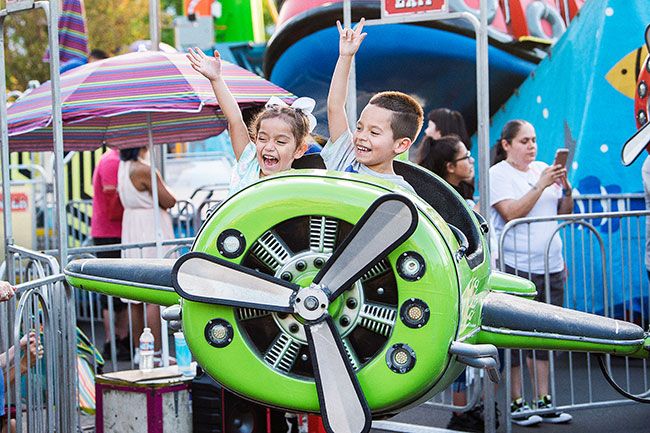 Marcus Larson/News-Register##
Emily Ramirez and her brother Alex wave to their parents as they fly by on a children s Turkey Rama Carnival ride.