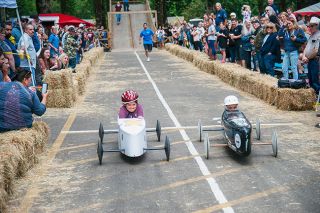 Kirby Neumann-Rea/News-Register##Grit shows in the faces of young racers Riley Mack, left, and Reed Regalado, in a photo-finish runoff during the annual soapbox car competition, in Beulah Park in Yamhill.