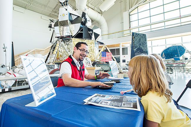 Marcus Larson/News-Register##
OMSI educator Alex Wiese talks with Aubrey MacKay and her twin sister,
Cassidy, about the different types of soil we find on Earth, Mars, and
the moon. The first rocks brought back from the moon were quarantined.