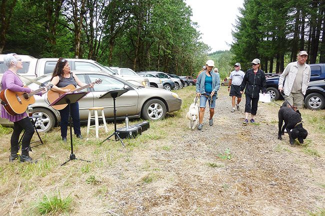 Starla Pointer / News-Register##
As the duo Luminous Heart (Jamie Corff and Val Blaha) performs, Donna and Andrew Scott, with blonde poodle Riviera and black poodle Monet,  join others hikers beginning the Timberland Trek 4 Trails Saturday. . The Scotts said they signed up not only to support Homeward Bound Pets, but also to give Monet and Riviera a nice walk and to practice for the upcoming Wine County Half Marathon, which will take place in mid-August.