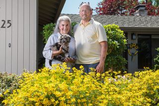 Rusty Rae/News-Register##
Sylvia and Kent Taylor and the latest addition to their family, labradoodle puppy Mac, named for McMinnville. Kent Taylor was McMinnville city manager for many years until he retired to have more time for gardening.