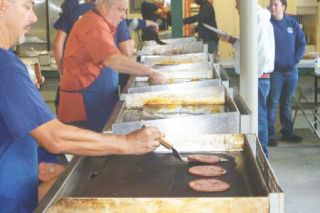Paul Daquilante/News-Register ## Amity Fire District volunteers work the griddles, preparing pancakes, sliced ham and eggs at Sunday morning’s annual pancake breakfast.
