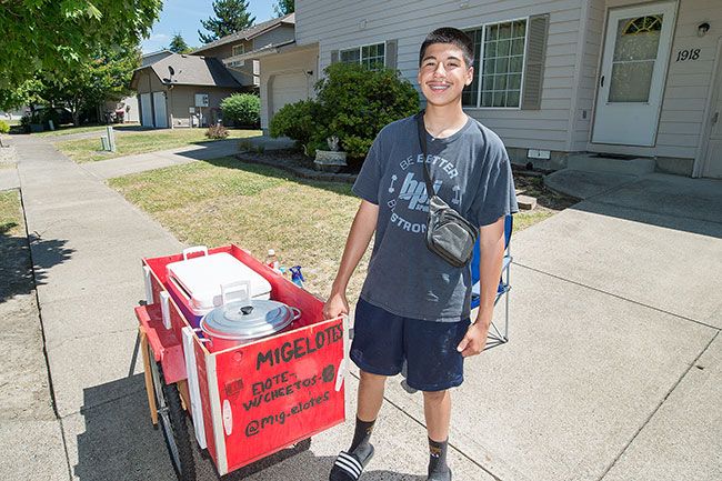Marcus Larson/News-Register ##  Miguel Lozano, a sophomore at McMinnville High School, worked with his dad building a cart to carry his elotes equipment. Customers can find the bright red cart on Fellows Street in southwest McMinnville.