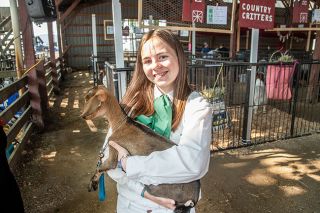 Rusty Rae/News-Register ##
Milanya Allen, a member of the Bacon Bits & Friends 4-H Club, holds a 7-week-old goat that soon will be entered along with its mom in the “Dam and Daughter” competition.