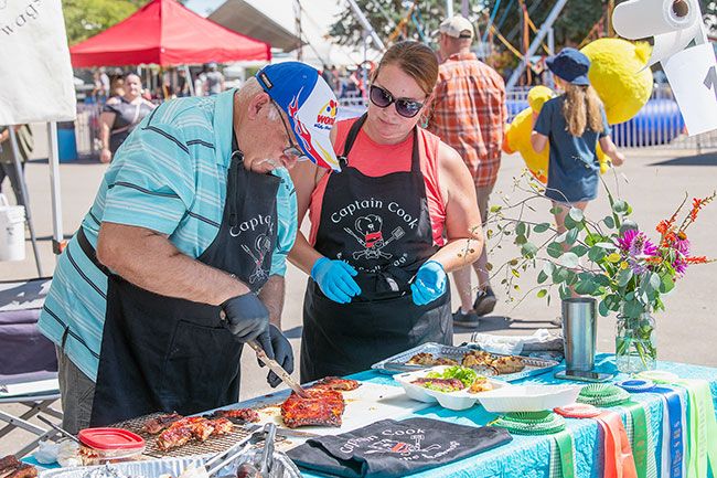 Rusty Rae/News-Register##
Charlie Carl and Heather Thomas check a rack of ribs for the perfect amount of doneness during the Yamhill County Fair’s barbecue competition Saturday. The Captain Cook team, which placed fourth, and other teams and individuals started cooking at 8 a.m. in hopes of winning the championship.