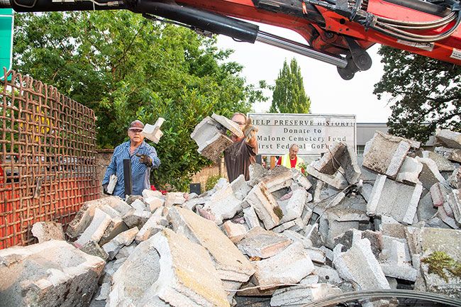 Rusty Rae/News-Register##
Members of the McMinnville Sunrise Rotary Club toss pieces of the broken cemetery wall into a waiting truck. Working on the project Saturday morning were, from left, Lou Perez-Leon, Jon Johnson and Dean Klaus.