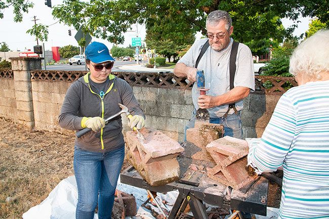 Rusty Rae/News-Register##
Janet Sasaki, Mark Paulette and and Dotty Holt chisel old mortar from the bricks that once formed the wall of the Malone Cemetery. The bricks are no longer produced, so members of the Sunrise Rotary Club preserved the old ones so they could be used again.