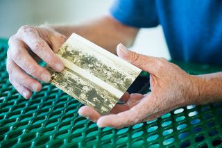 Rusty Rae/News-Register##Goularte shows off a vintage postcard he found online.