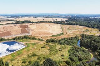 Jake Volz/Eagle Eye Droneography##An aerial photo shows Riverbend Landfill rising above the South Yamhill River. A leachate pond constructed between the landfill and the river is intended to capture and store toxic runoff, which is later trucked offsite.