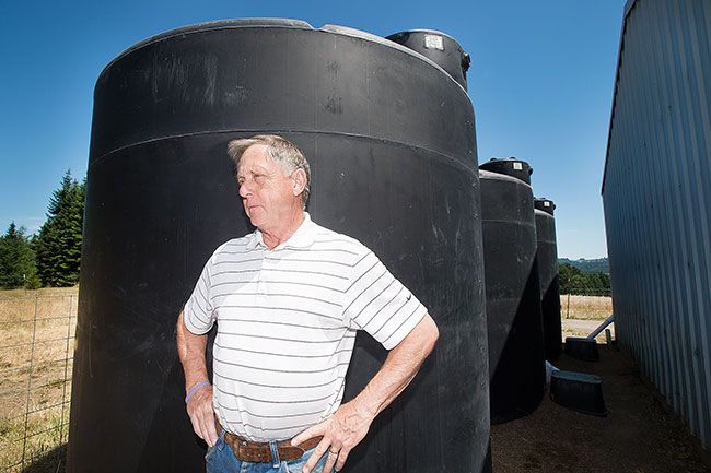 Marcus Larson / News-Register##Carlton farmer Jim Botten collects 21,000 gallons of rainwater each year, storing it in large tanks. He uses one tank at a time, controlling the water flow with faucets.