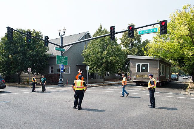 Marcus Larson/News-Register##
Police and local officials discuss the best way to back up the manufactured home onto Lafayette Ave.