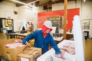 Rusty Rae/News-Register##
Jessica Thomas, retail manager, stocks the freezer in the Carlton Farms store with pork and beef products. Meats, including Carlton Farms  popular sausages and bacon, are available in the store Monday through Saturday.