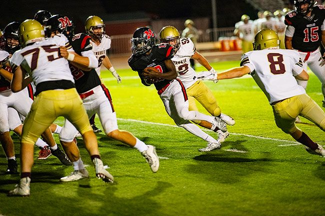 Rusty Rae/News-Register##
Kirby Hartzell heads up the gut during the third quarter of McMinnville s game with Milwaukie, scoring the Grizzlies  final TD of the night in a 41-7 season opening victory.