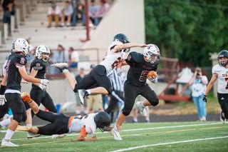 Rusty Rae/News-Register##Yamhill-Carlton defensive backs Max Armstrong (in air) and Spencer Stiff launch themselves at Dayton running back Zack Smith in an attempt to slow the powerful Pirate. Smith finished with 209 rushing yards and four touchdowns.