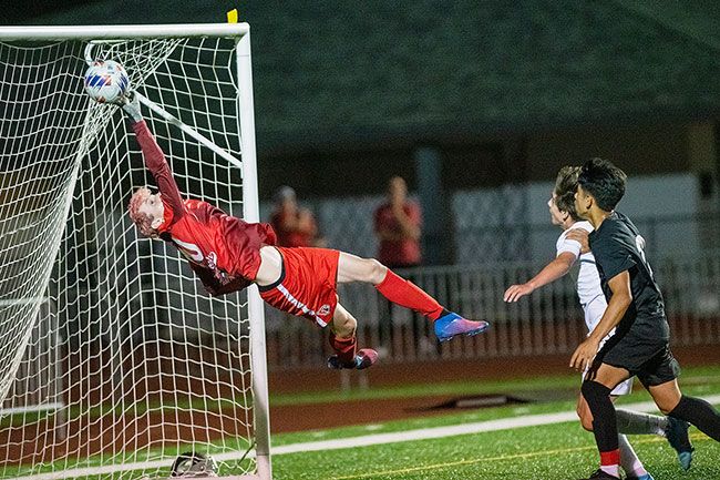 Rusty Rae/News-Register##Lincoln goalie Alexander Rhodes leaps backward and barely saves a head shot attempt by McMinnville’s Giovanni Grimaldo in the second half, nearly the third equalizer of the game for the Grizzlies.