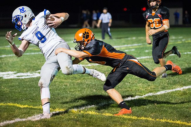 Marcus Larson/News-Register##
Yamhill-Carlton s Kyle Shipley makes a leaping tackle on Valley Catholic s Cade Napoli for the defensive stop.