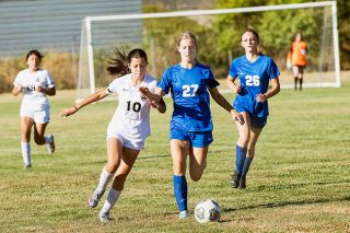 Rusty Rae/News-Register##Amity’s Eliza Nisly holds off Itzel Cortes of Dayton as he dribbles down the field.