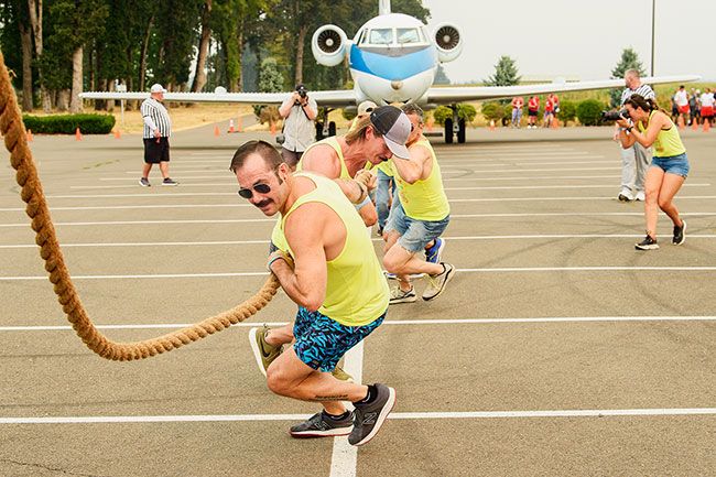 Rusty Rae/News-Register##
Team You Can t Boat With Us hoists the thick rope attached to the NASA jet, and pulls as one while competing in the Special Olympic Plane Pull Saturday at Evergreen