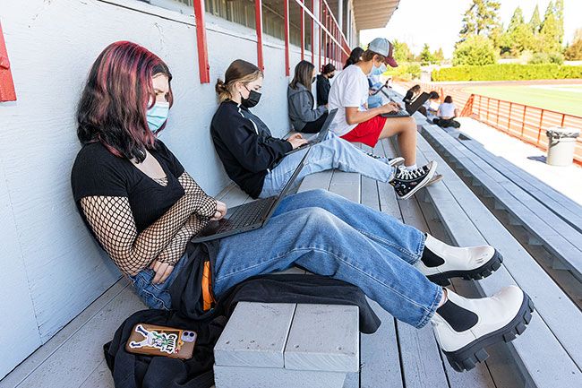 Marcus Larson/News-Register ## On the McMinnville High School stadium bleachers, Alannah Doherty, her friend Gracie Mackay and other students in Wendy Maselli’s Advanced Language and Literature class write letters of introduction to their teacher, their first assignment of the year.