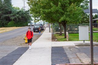 Rusty Rae/News-Register##
Dayton student Brody Jimenez walk toward the high school and junior high on a new stretch of sidewalk that runs along Ferry Street. The city won a grant to pay for new walkways on a stretch of road where students once had to  walk in the street.