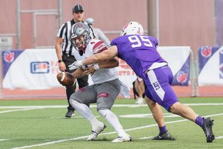Rusty Rae/News-Register##Linfield defensive end Vinny Niosi pulls down Redlands quarterback Myles Herrera during the Linfield-Redlands contest Saturday. Nioisi got the sack after a snap to Herrera went over his head. The ‘Cat defense had five sacks on the day in the 21-3 victory.