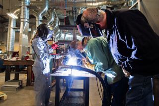 Marcus Larson/News-Register##
Teacher Chip Ford observes as students Madysen Chesnik and Mathew Perlot weld a table stand. The welding room in the new Career Tech Center is larger and more update than the previous one.